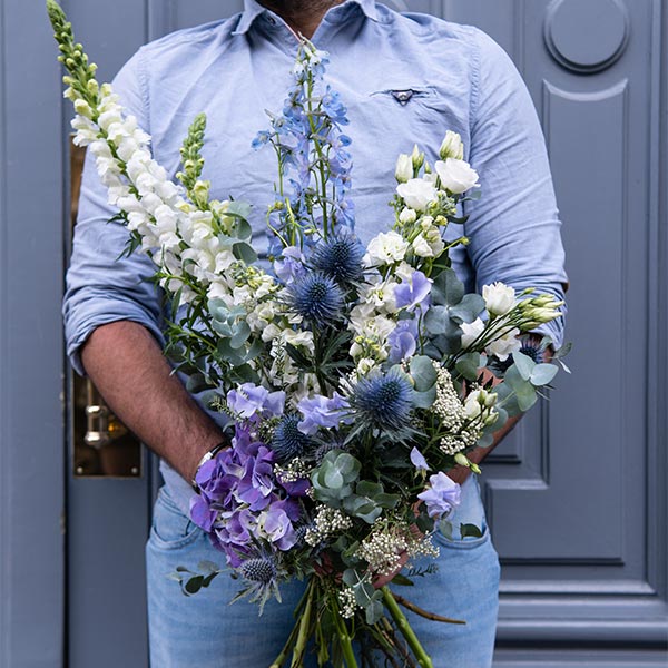 bouquet destructure violet tenu par un fleuriste