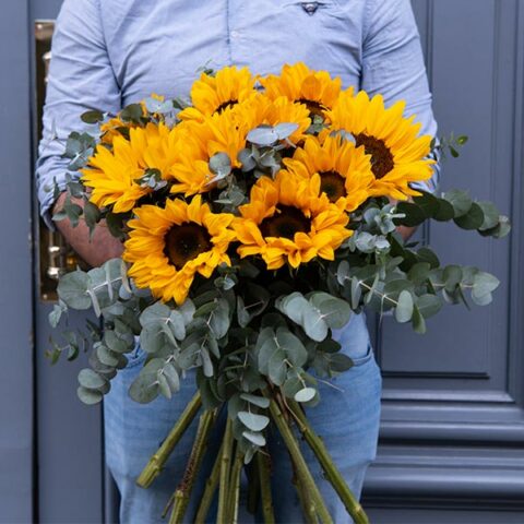 bouquet de tournesol tenue par un fleuriste
